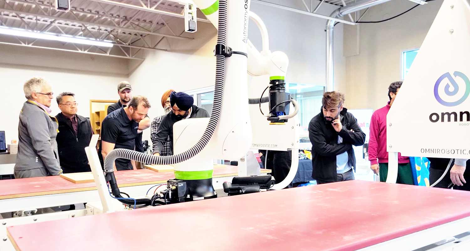A crowd of attendees gathers to watch the PSA-80 Pro expertly sanding a kitchen cabinet panel during the live demo at the Focus Show, Delta, BC, April, 2024.