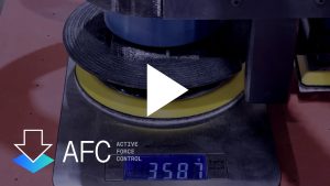 Video thumbnail of a weight testing machine showing a tension roller and digital scale readout, with a large white play button overlaying the center.