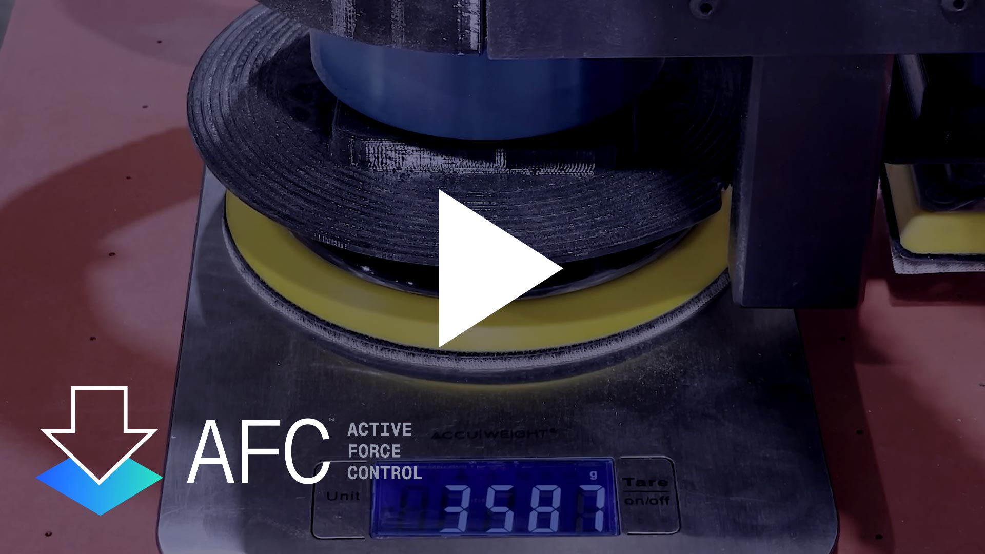 Video thumbnail of a weight testing machine showing a tension roller and digital scale readout, with a large white play button overlaying the center.